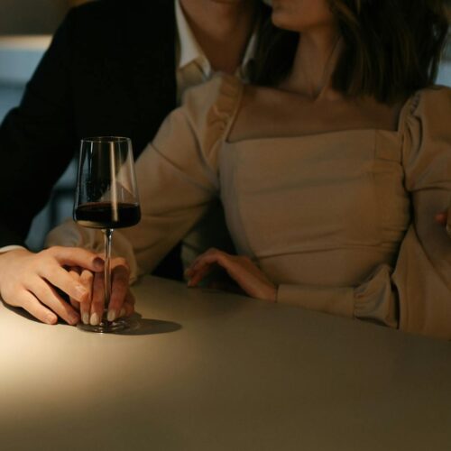 Woman in Beige Long Sleeve Shirt Holding Wine Glass